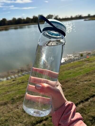 Clear water bottle held in a hand