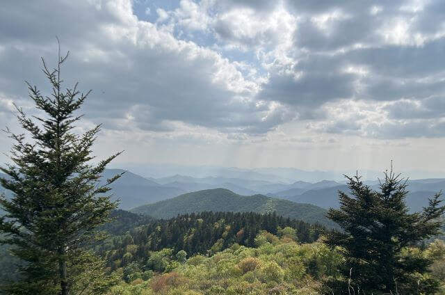 Blue mountain ridges with light splitting the clouds above