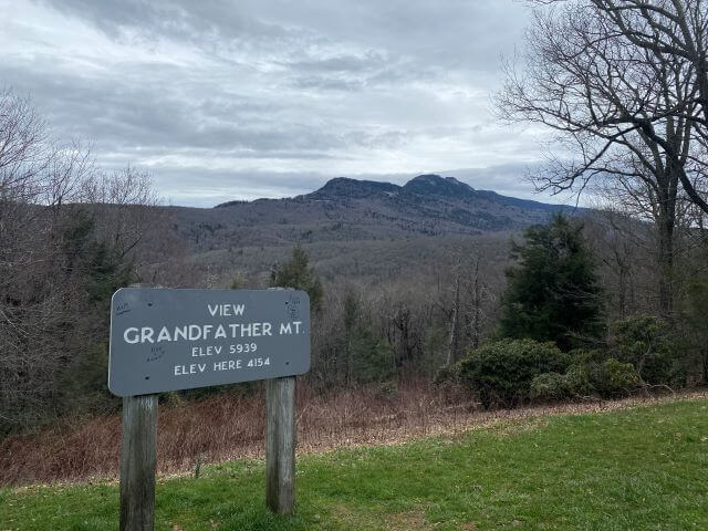 wooden sign with grandfather mountain behind it