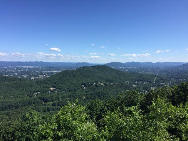 green mountains with a city in the valley below