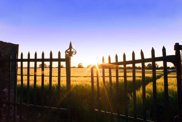 fence open in front of a field of grass