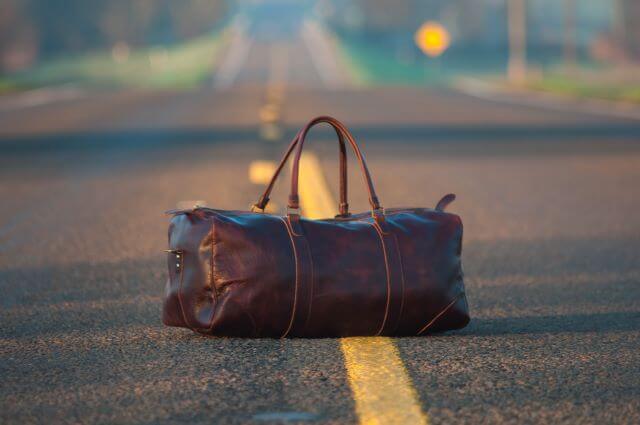 brown leather bag in the middle of a road