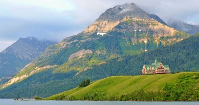 historic building in front of lake and mountains
