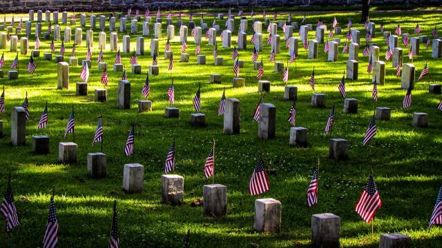 rows of tombstones decorated with American flags