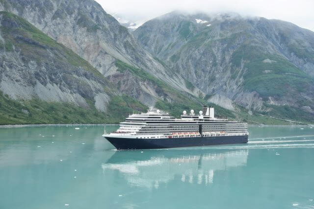 a large cruise ship in front snowy mountains