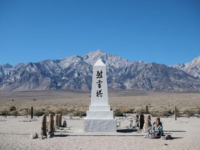 tall white memorial stone with black japanese text