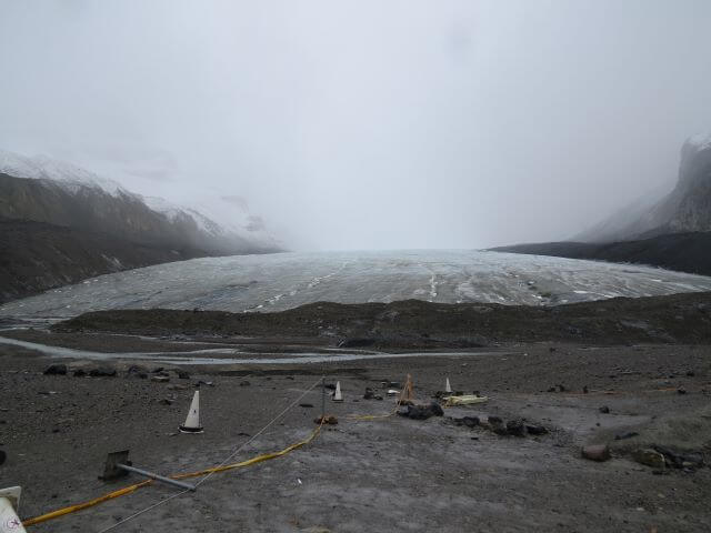 flat white glacier surrounded by mud