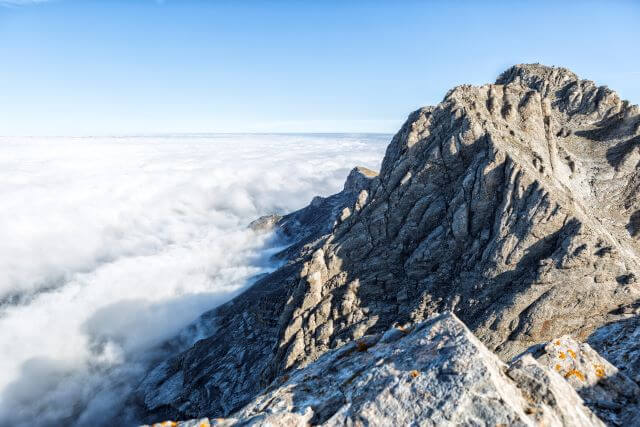 a rugged mountaintop above the clouds