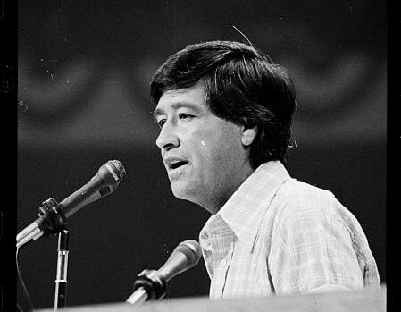 a man speaks at a microphone