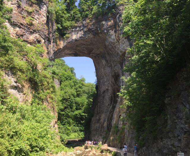 a massive stone arch surrounded by trees