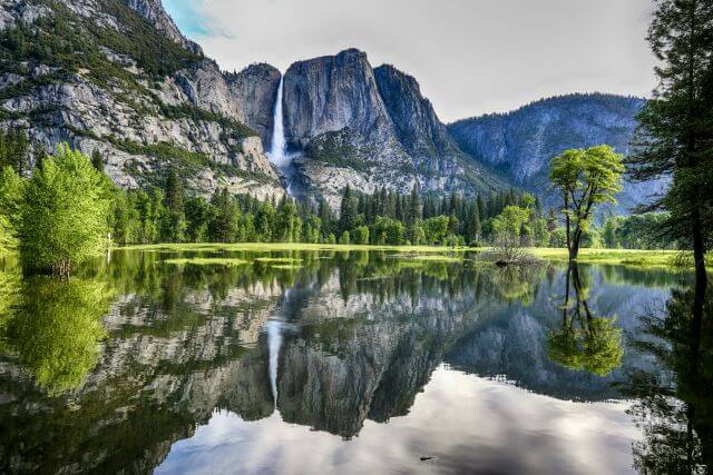 mountains and waterfalls reflected in a lake
