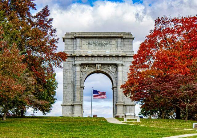 a stone arch framing the American flag