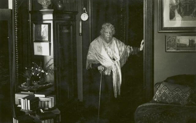 a historic photo of an elderly woman in her home