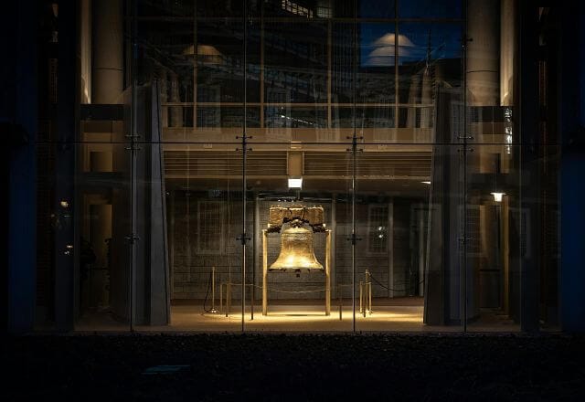large bell under lights in a dark room