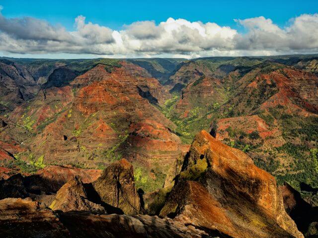 red and green mountains under a blue sky