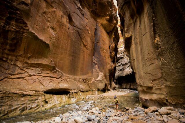 two hikers between high, narrow canyon walls