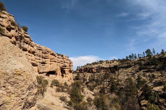 vertical stone cliffs with ancient rooms dug out