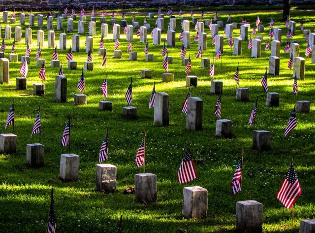 a row of tombstones decorated with american flags